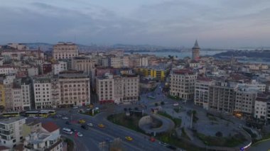 Şehir merkezindeki şehir merkezinin üzerinde ilerliyorlar. Popüler turist manzaralı eski çok katlı apartmanlar, alacakaranlıkta Galata kulesi. İstanbul, Türkiye.