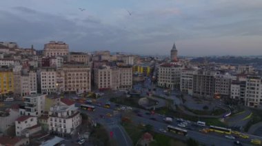 Şehir merkezindeki işlek caddede alacakaranlıkta yoğun trafiğin hava görüntüsü. Arka planda tarihi Galata kulesi. İstanbul, Türkiye.