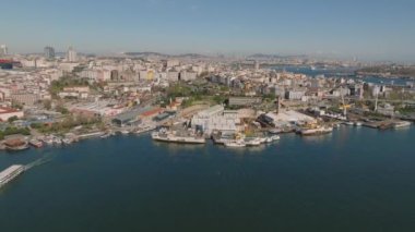 Körfez kıyısındaki tersanelerin havadan görüntüsü. Endüstriyel alan ve metropoldeki şehir merkezindeki konut binaları. İstanbul, Türkiye.
