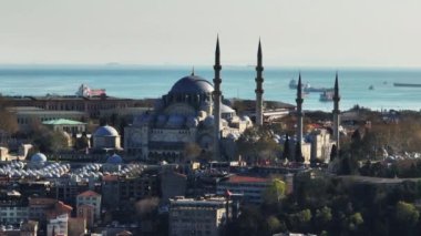 Arka planda inanılmaz tarihi doğu dini yapısının ve deniz kıyısındaki gemilerin havadan görünüşü. Minareli Süleyman Camii. İstanbul, Türkiye.