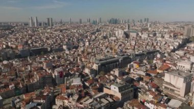 Metropolün altın saatindeki hava panoramik görüntüsü. Yoğun şehir gelişimi ve arka plandaki modern yüksek katlı ofis binaları. İstanbul, Türkiye.