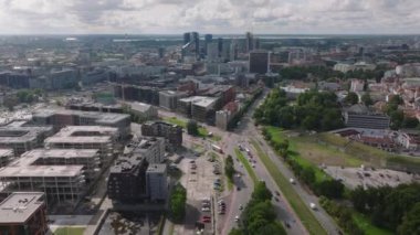 Modern kentsel bölgenin üzerinden geriye doğru uçar. Caddede yeni gelişmeler ve uzaktaki yüksek katlı ofis binaları. Tallinn, Estonya.