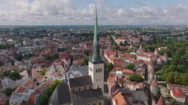 Yüksek kilise kulesinin havadan görünüşü ve eski kasabadaki tarihi evler. Ortaçağ turist manzarası Oleviste kogudus. Tallinn, Estonya.
