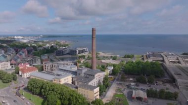 Forvetler artık sanat ve bilim merkezi olarak kullanılan eski enerji santralinin üzerinde uçuyor. Deniz kıyısına yakın tuğla fabrikası bacası. Tallinn, Estonya.