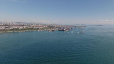 Metropolis, güneşli bir günde deniz kıyısında. İleri su yüzeyinin üzerinden limana doğru uçuyor. İstanbul, Türkiye.