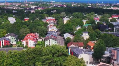 Kentsel yerleşim yerlerindeki evlerin hava kaydırak ve pan görüntüleri. Renkli cepheler ve yeşil ağaçlarla çevrili binalar. Tallinn, Estonya.