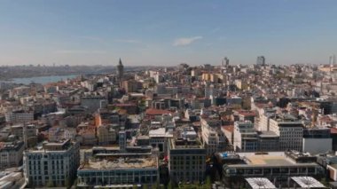 İleri, büyük şehrin üzerinde uçar. Şehirdeki yerleşim yerlerinde sıra sıra binalar. Galata Kulesi 'nin tarihi turistik simgesi. İstanbul, Türkiye.