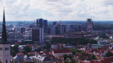 Şehirdeki çeşitli binaların havadan kayma ve pan görüntüleri. Şehir merkezindeki yüksek katlı ofis kuleleri ve tarihi binalar. Tallinn, Estonya.