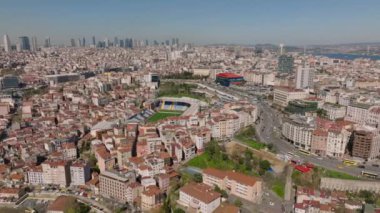 Büyük şehrin hava panoramik görüntüleri. Şehir merkezindeki futbol stadyumunun etrafındaki binalar. Mesafeli yüksek ofis kuleleri olan şehir manzarası. İstanbul, Türkiye.