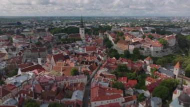 Tarihi şehir merkezinin üzerinden geriye doğru uç. Eski evler ve dar koridorlar. Kiliseyi yüksek kuleyle aydınlatmak. Tallinn, Estonya.