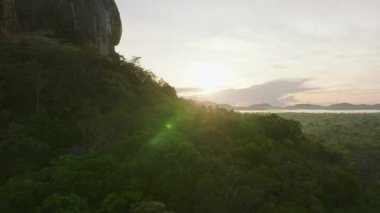Tropikal ormanlardaki ağaçların tepelerinde altın saatinde ilerliyorlar. Gün doğumunda manzara manzarasını gözler önüne seriyor. Sigirya, Sri Lanka.