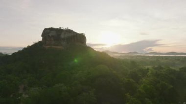 Tropikal yeşil ormanlarla çevrili popüler Aslanlar Kayası 'nın hava görüntüleri. Güneşin doğuşuna karşı sabah çekimi. Sigirya, Sri Lanka.