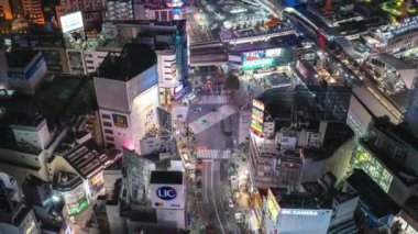 Akşam Shibuya Geçidi 'nden geçen araba ve yayalar. Metropolis 'teki kalabalık kavşakların yüksek açılı görüntüsü. Tokyo, Japonya.