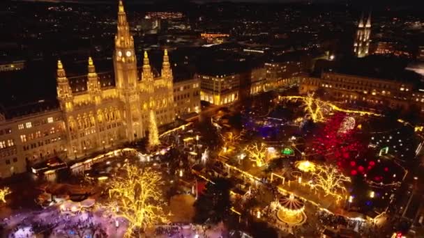 在圣诞市场的时候飞越拉瑟斯公园 夜间航拍彩灯 照亮了历史性的市政厅 奥地利维也纳 — 图库视频影像