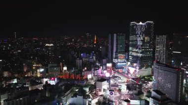 Gece Metropolis 'in üstünde uç. Shibuya bölgesindeki sokakları ve meydanı zenginleştirdi. Modern yüksek binalar. Tokyo, Japonya.