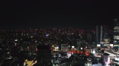 Metropolis 'in geceleri çekilmiş panoramik görüntüleri. Şehir merkezindeki binalar ve caddelerin üzerinden uçuyor. Tokyo, Japonya.