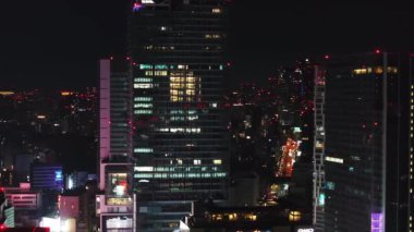 Parlak cam cepheli modern yüksek binaların hava kaydırak ve pan görüntüleri. Gece şehri sahnesi. Tokyo, Japonya.