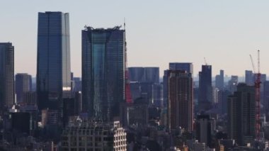 Büyük şehirlerdeki apartmanların modern gökdelenlerinin havadan çekilmiş görüntüleri. Tokyo Kulesi 'nin kırmızı çelik kafes yapısı ortaya çıkıyor. Tokyo, Japonya.