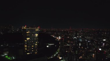İleri, modern konut kulesinin etrafında uçar. Gece manzarası. Metropolis 'in büyük bir alanı. Tokyo, Japonya.