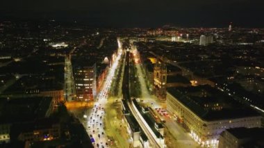İleriye doğru çok şeritli işlek caddelerin üzerinde yüksek patikalarla uçun. Akşam şehrinin hava manzarası. Viyana, Avusturya.