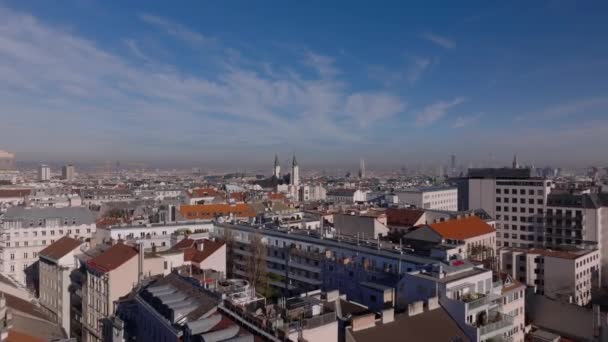 その後 都市部の住宅のブロックの上を飛ぶ ピアリスト教会の塔に向かう 大都市のパノラマビュー ウィーン オーストリア — ストック動画