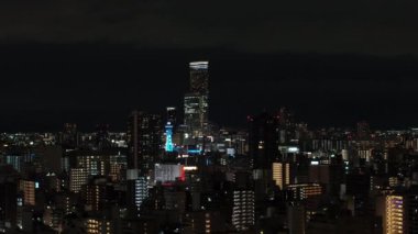 Modern gökdelen ofislerinin ya da şehir merkezindeki kulelerin hava kaydırak ve pan görüntüleri. Gece şehri sahnesi. Osaka, Japonya.