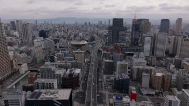 Metropolün havadan panoramik görüntüsü. Modern şehrin içinden geçen çok şeritli ana yol. Yüksek binalar. Osaka, Japonya.