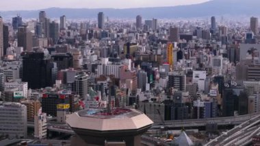 Metropolis 'teki yoğun şehir gelişimi. Şehirdeki binaların havadan görüntüsü. Yükseltilmiş caddede giden araçlar. Osaka, Japonya.