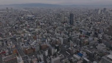 Metropolün havadan panoramik görüntüsü. Şehir merkezindeki konut binaları. Osaka Kubbesi uzakta. Osaka, Japonya.
