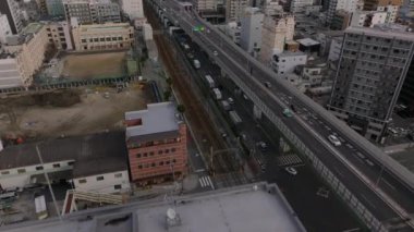 Şehirdeki ulaşım altyapısının yüksek açılı görüntüsü, çok katlı cadde ve demiryolu rayları. Yukarı kaldır ve şehir manzarasını göster. Osaka, Japonya.