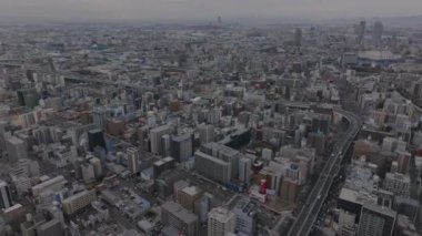 Metropolis 'in hava panoramik görüntüleri. Büyük şehirde yükseklikten çeşitli binalar. Yollarda trafik vardı. Osaka, Japonya.