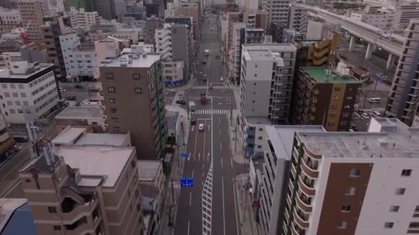 前进在市区宽阔的街道上方飞行 车辆通过十字路口 城市的多层住宅建筑 日本大阪 — 图库视频影像