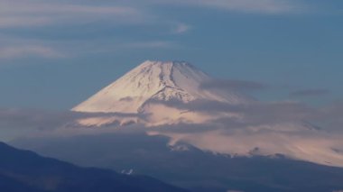 Fuji Dağı 'nın altın saatindeki yakınlaştırılmış görüntüsü. Beyaz karla kaplı yüksek konik volkan zirvesi. Japonya.