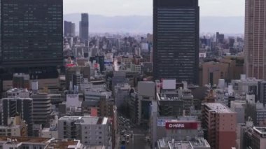 Metropolis 'teki yoğun şehir gelişiminin havadan yükselen görüntüleri. Modern yüksek binalar çevrenin üzerinde yükseliyor. Osaka, Japonya.