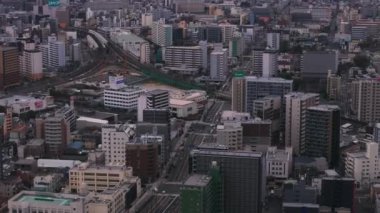 Şehrin gelişiminin havadan görüntüsü. Şehirdeki binalar, sokaklar ve raylar. Osaka, Japonya.