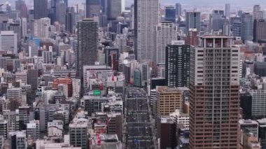 Şehirdeki yoğun şehir gelişiminin hava görüntüleri. Şehir merkezindeki yüksek katlı apartmanlar. Osaka, Japonya.