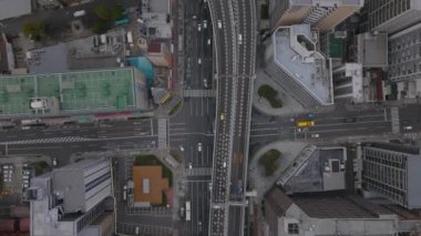 Şehirdeki ulaşım altyapısının üzerinden uç. Yükseltilmiş caddede giden araçların kuş bakışı görüntüleri. Osaka, Japonya.