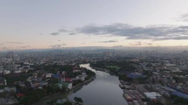 Gün doğumunda şehir manzarasının havadan çekilmiş görüntüleri. Pasig Nehri 'nin sakin yüzeyi ve kıyıya demirlemiş kargo gemileri. Manila, Filipinler.