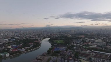 Metropolis 'in alacakaranlıktaki hava panoramik görüntüleri. Şehir merkezinden akan nehir. Manila, Filipinler.