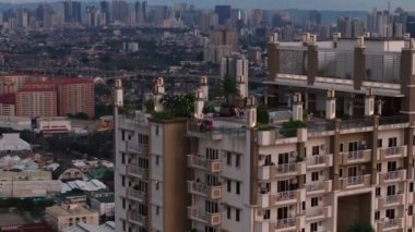 İnsanlar yüksek katlı terasın manzarasını seviyorlar. Torre de Manila ve şehrin arka planda yükselen görüntüsü. Manila, Filipinler.