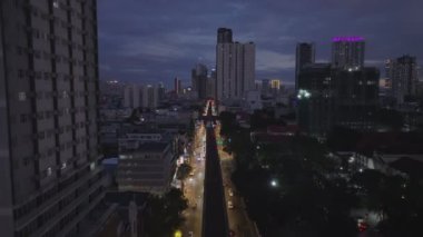 Gece şehrindeki kalabalık çoklu şeritli caddenin havadan görüntüsü. Yükselen çekim akşam manzarasını gözler önüne seriyor. Manila, Filipinler.