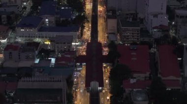 Ortasında demiryolu hattı olan çok şeritli bir yolun hava görüntüleri. Akşam kentinde yüksek açılı ulaşım manzarası. Manila, Filipinler.