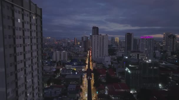 夜の街並みの映像を上昇する空中 高い建物と照らされた通りを持つ大都市の素晴らしいパノラマビュー マニラ フィリピン — ストック動画