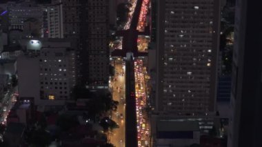 Şehir merkezindeki çok şeritli yoldaki yoğun trafiğin yüksek açılı görüntüsü. Arabalar yüksek binalarla çevrili caddede sıkışıp kalmış. Manila, Filipinler.