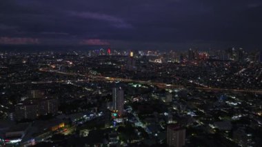 Metropolün havadan panoramik görüntüsü. Şehirdeki binaların ve sokakların üzerinden uç. Yoğun caddelerdeki araçlar ve modern şehir merkezindeki yüksek binalar. Manila, Filipinler.