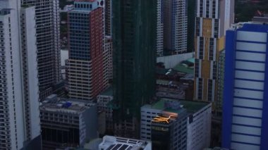 Metropolis 'teki modern yüksek binalar. Günbatımında deniz kıyısındaki liman ve gemileri göster. Manila, Filipinler.