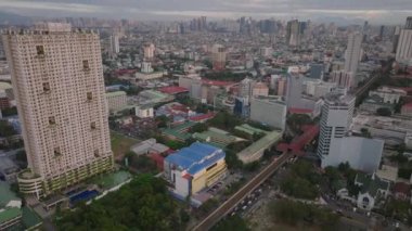 Şehir merkezindeki binaların yüksek açılı manzarası. Şehir manzarasını yukarı kaldır, arka planda yüksek katlı kuleler var. Manila, Filipinler.