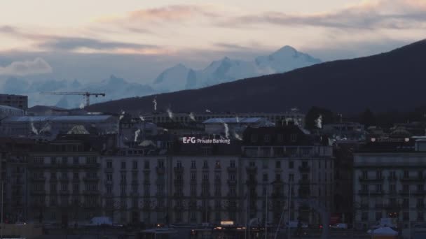 都市のボロと高い山の頂上にある多様な建物の朝の景色は 空の輝く雲に対して ジュネーブ スイス — ストック動画
