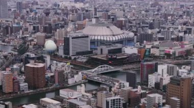 Osaka Kubbesi 'nin hava ve pan görüntüleri. Şehir merkezindeki binalarla çevrili modern tasarım beyzbol stadyumu. Osaka, Japonya.