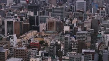 Modern şehirde yoğun şehir gelişimi. Şehir merkezindeki çok katlı apartman binaları. Osaka, Japonya.